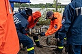 Einsatzkräfte des Fachzuges Wasserschaden/Pumpen kuppeln den Saugschlauch einer Hochleistungspumpe. Foto: THW/ Michael Appelfelder